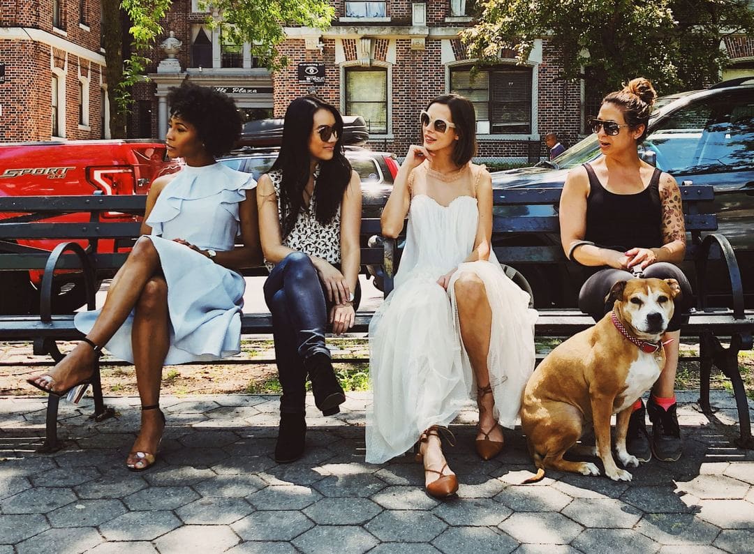 chris-murray-PXVQ7SNqdME-unsplash (1) (1) (1) 個性的な女性4人がベンチに座り犬が1匹座っている